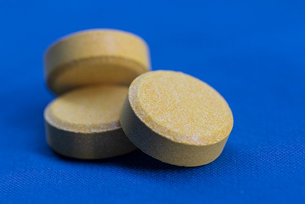 A closeup of yellow colored medicine on a blue cloth