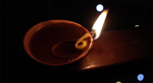 Diya closeup and lights in the background