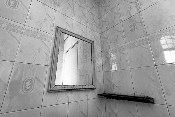 a square shaped mirror in the bathroom